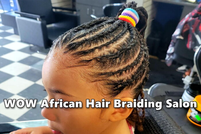 Young girl with classic straight-back cornrows braided into a ponytail at kids hair salon.